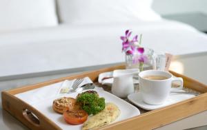 峇六拜槟城橄榄树酒店的盘子,盘子上放着一盘食物和一杯咖啡