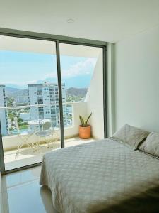 圣玛尔塔Nuevo, amoblado y las mejores vistas de amaneceres的一间卧室设有一张床,享有阳台的景色