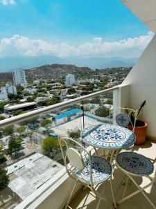 圣玛尔塔Nuevo, amoblado y las mejores vistas de amaneceres的阳台配有2张桌子和椅子,享有城市美景。