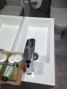 阿波罗湾海浪汽车旅馆&公寓的浴室内带水龙头的盥洗盆