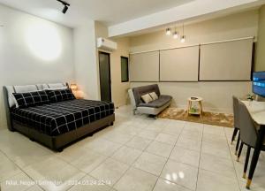 汝来Cozy Homely Studio @ Youth City Residence Nilai的一间卧室配有一张床、一张沙发和一张桌子