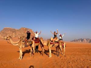瓦迪拉姆Faisal Wadi Rum camp的一群人骑着骆驼在沙漠中