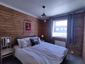 MefjordværNorwegian house Maria Stua的一间卧室设有一张大床和一个窗户。