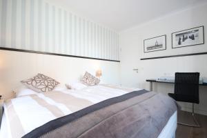 万根沃格Haus Anna - Wohnung 3的白色卧室配有床和书桌