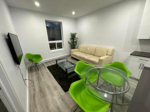 蒙特利尔Appartement 2 chambres - 202的客厅配有沙发、桌子和绿色椅子