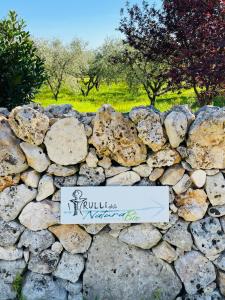 马丁纳弗兰卡I PapaTrulli Resort - I Trulli della NaturaBio的墙上有标志的石墙