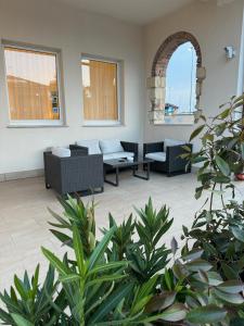 卡斯特努沃德加尔达多里酒店的带沙发、椅子和植物的客厅