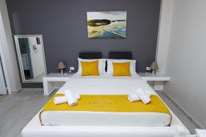伏罗拉Guest House Narta的卧室配有一张带黄色枕头的大型白色床。
