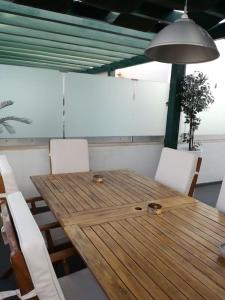 Praia VerdeCasa Bambu, Paraiso na Terra的一张带白色椅子和台灯的木制餐桌