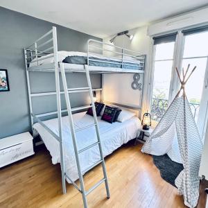 塞里斯Cosy Apartment Carré Elysée Serris的一间卧室配有一张双层床和梯子