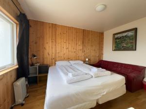 斯塔奥尔Fagrabrekka Private Room的一间卧室配有一张床和一张红色的沙发