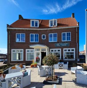 赞德沃特Boutique Lodge Zandvoort的前面有白色家具的红砖建筑