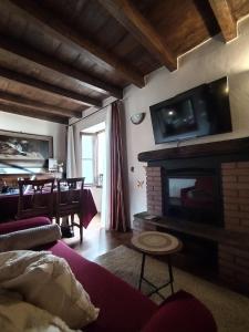 贝拉诺Little Country House的客厅设有壁炉和墙上的电视