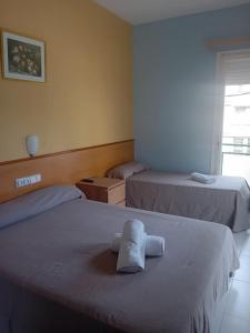 塞古德卡拉斐Hotel Sant Jordi的一间设有两张床铺和毛巾的房间