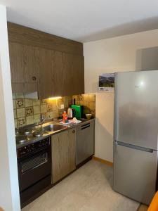洛伊克巴德Montanji 11的厨房配有不锈钢冰箱和水槽