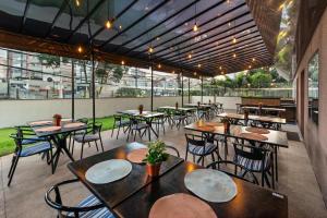 瓜鲁柳斯Flat Hotel Slaviero Guarulhos的餐厅设有桌椅和窗户。