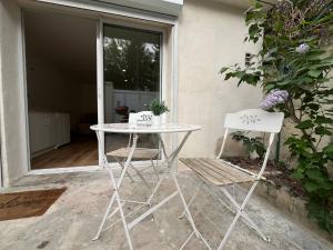 阿维尼翁Studio avec terrasse proche du centre ville d'Avignon的庭院里配有一张白色的桌子和两把椅子