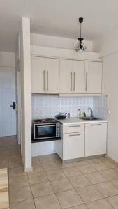 美西尼Cozy Nights的厨房配有白色橱柜、水槽和微波炉