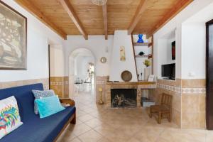 里戈尔Casa dos Peixinhos - Rogil的客厅设有蓝色的沙发和壁炉