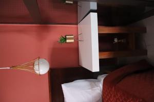 纳米贝Casa 2的一间卧室设有红色墙壁、一张床和一盏灯