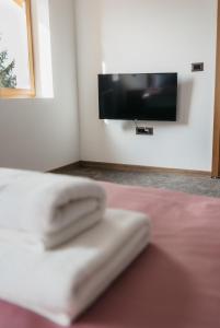 Babina GredaPansion Mihića dvori的床上一双毛巾,墙上有电视
