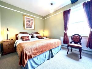 萨彻姆Colthrop Manor B&B的卧室配有床、椅子和窗户。