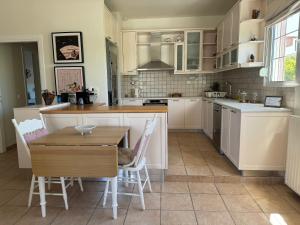干尼亚Primavera Retreat的厨房配有白色橱柜和桌椅
