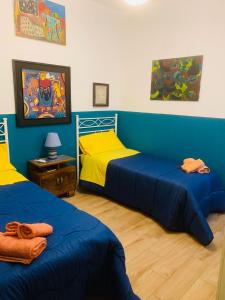 马尔扎梅米Casa Franca a Marzamemi的蓝色和黄色的客房内的两张床