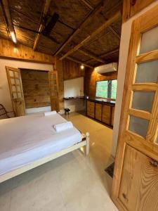 卡纳科纳Jeet Hostel & Rooms的一间带一张床的卧室,位于带木制天花板的房间内