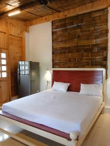 卡纳科纳Jeet Hostel & Rooms的一间卧室设有一张带木墙的大床