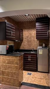 艾卜哈أبها مارينا فيلا的厨房配有木制橱柜和不锈钢冰箱。