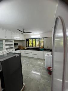 浦那Luxurious 2Bhk Fully Furnished apartment的一间设有白色橱柜和窗户的大厨房