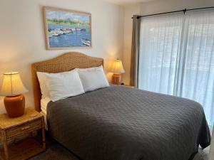 新港海星角公寓式酒店的一间卧室配有一张带两盏灯的床和一扇窗户。