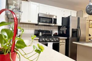 诺斯布鲁克Green #23的厨房配有白色橱柜和不锈钢冰箱