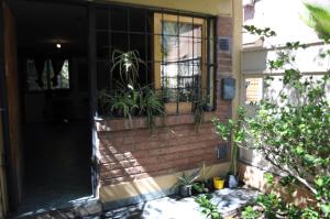瓜伊马延Alojamiento + Casa de Arte en Mendoza(ARG)的砖房,上面有窗户和植物