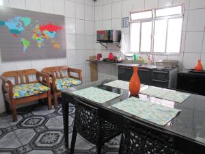 瓜鲁柳斯AEROHOSTEL Brasil的厨房配有一张桌子和两把椅子,墙上有一张地图