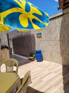 拉巴拉德纳圣米格尔Casa Meu Cantinho的天井配有桌子和黄色雨伞
