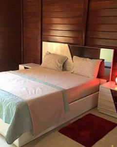 BelasResort Nabruni的一间卧室配有一张大床和木制床头板