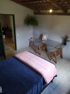 卡瓦坎特Hostel do Cerrado的卧室配有1张床、1张桌子和1把椅子
