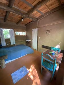 圣安娜Eco Posada Tierra Fértil的一间卧室配有一张蓝色的床和一张桌子