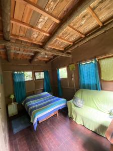 圣安娜Eco Posada Tierra Fértil的一间卧室设有两张床和蓝色窗帘