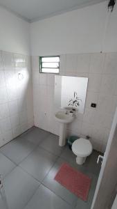 卡瓦坎特Hostel do Cerrado的白色的浴室设有水槽和卫生间。