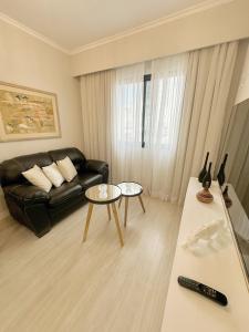 圣保罗Sao Paulo Ibirapuera Privilege - Suite Deluxe的客厅配有黑色沙发和桌子