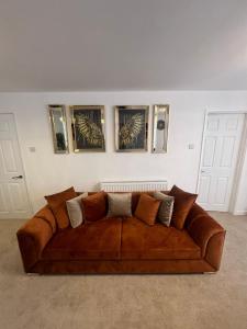巴恩斯特珀尔Elegant House的墙上有三张照片的房间里一张棕色的沙发