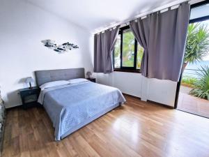 卡普多兰多Villa Anita Apartments的一间卧室设有一张床和大窗户