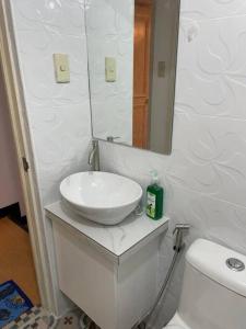 San Andresspick and span condo的白色的浴室设有水槽和卫生间。