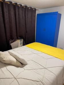 San Andresspick and span condo的一间卧室配有一张床和一个蓝色的门