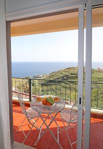 卡尼索Vista Reis Magos的一个带桌椅的海景阳台