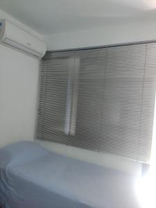 阿雷格里港Próximo ao Consulado - Quarto Inteiro的一间卧室配有一张床和一个带百叶窗的窗户