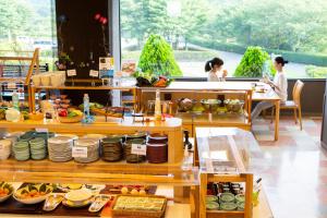 高森町Kyukamura Minami-Aso的餐厅的自助餐,有坐在桌子上的人